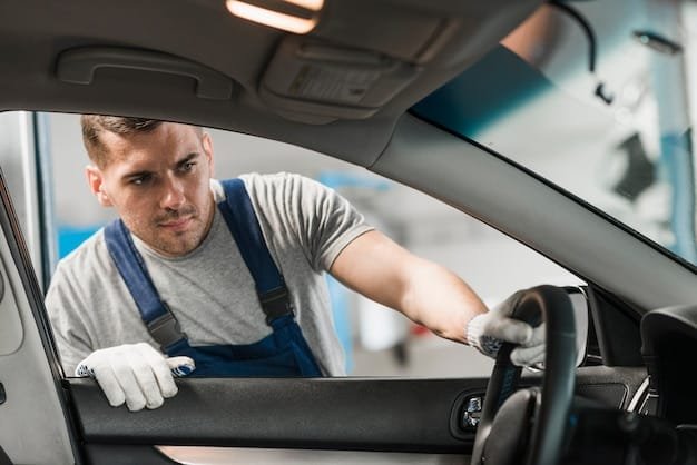 a man in a blue overalls holding a steering wheel - Auto glass Services - Save On Auto Glass